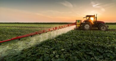 Traktor fährt auf dem Feld und bringt Pestizide aus